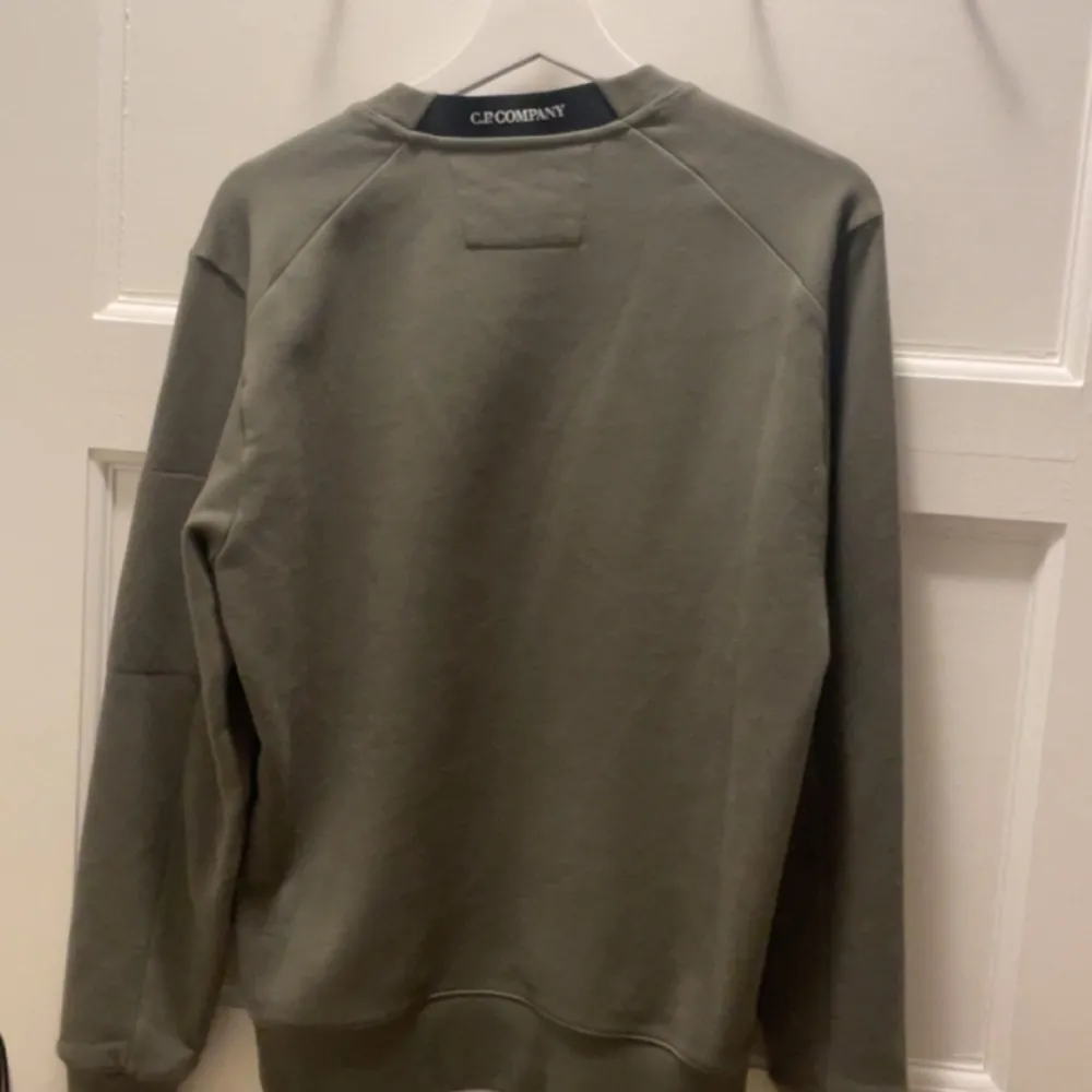 En aldrig använd CP company sweatshirt i färgen grön. Tröjan är köpt på johnells för 1999kr Säljer då jag inte gillar färgen.. Hoodies.
