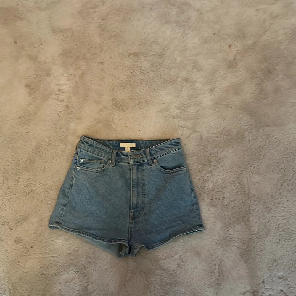 Blåa högmidjade jeansshorts från H&M, i storlek 38 . Shorts.