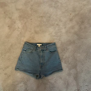 Jeans shorts  - Blåa högmidjade jeansshorts från H&M, i storlek 38 