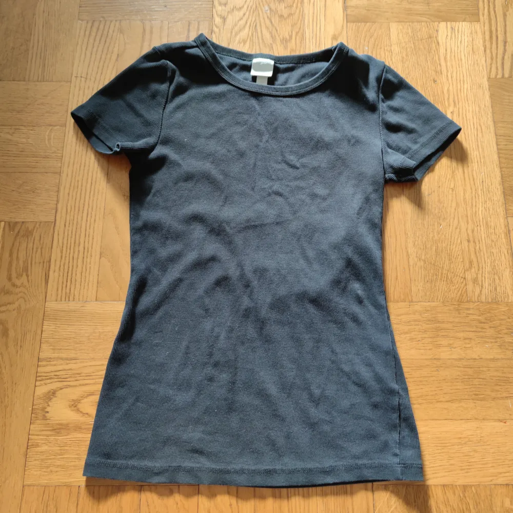 Svart ribbad t-shirt från h&m. Den är lite tajt i modellen. . T-shirts.