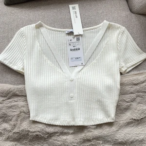 Tröja - En helt ny vit zara tröja som aldrig har används i storlek S. Har lite fina detaljer och är en liten kort tröja.