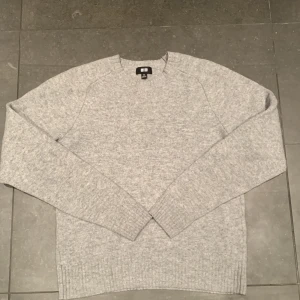 Uniqlo ulltröja - Uniqlo grå ulltröja i använt skick utan några större defekter förutom att den har krympts i tvätten så passar någon storlek mindre, originella storleken är xs så den borde passa xxs eller vissa barnstorlekar.