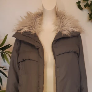 Vintage jacka - Fin, varm och go jacka med lurvig krage, syntetpäls. Jackan är i snygg grå,färg färgen på bilden stämmer inte riktigt. Använd nen i gott skick.