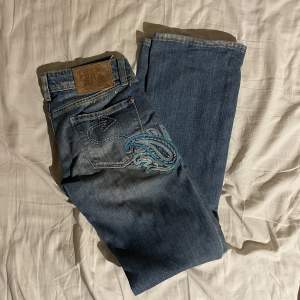 Lågmidjade bootcut jeans i bra skick med otroligt fina detaljer. Säljer endast vid bra pris, hör av dig vid frågor