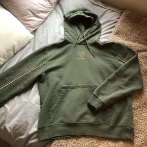 Hoodie - Säljer min militärgröna hoodie med rosa detaljer! Är i fint skick, skriv för yttligare frågor!