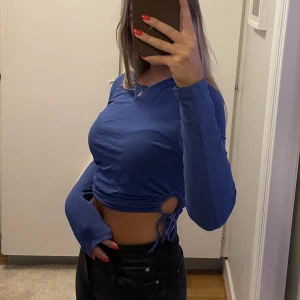 Blå topp - Croppad blå topp med detaljer i midjan från vero Moda i strl S! Endast använd 2 gånger så mycket bra skick! Nypris 249kr