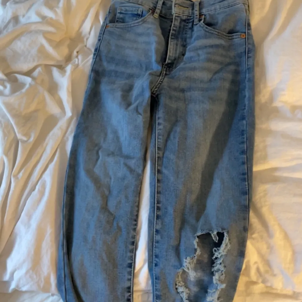 Ett par Levis jeans med hål i ena knät. Tighta med lite slit längst ner. XS . Jeans & Byxor.