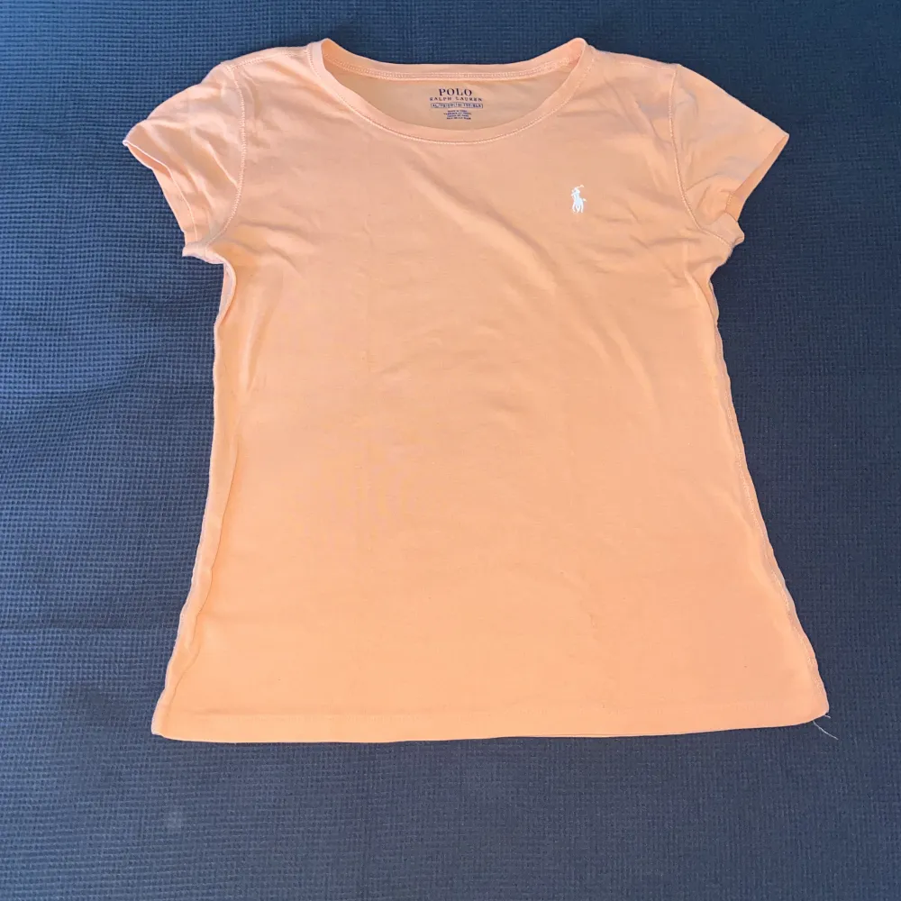 Sjukt fin t shirt som är figurnära och i en mycket fin aprikos färg! Färgen syns inte alls bra på kamera men är orange-rosa (lite mer rosa irl). Köpt för dryga 600kr i Florida. . T-shirts.