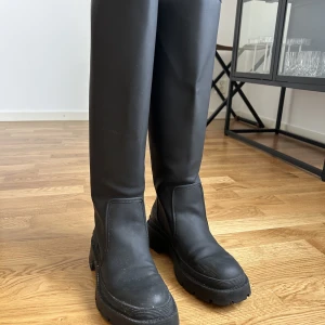 Stövlar Zara  - Säljer svarta stövlar i gummi från zara i storlek 39 Som man kan se på sista bilden så har lite gummi lossnat därav priset 