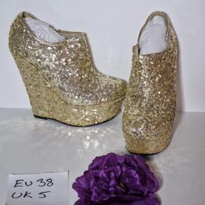 Snygga high heels i guldfärgade paljetter Klackhöjd ca 15 cm Platå ca 5 cm Helt nya och oanvända