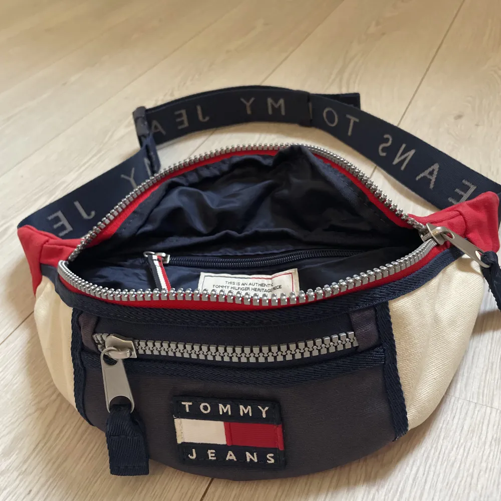 Tommy jeans Bum bag i blå , röd och vit. Justerbart band. Använd.  Finns tecken på blekning av färgen från ex sol. . Väskor.