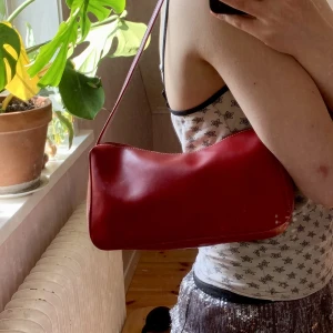 Röd väska  - Liten röd väska med vita sömmar. Det finns en liten ficka på insidan. Några så täcken på användning men inget att man ser om man inte tittar noga. 🤍