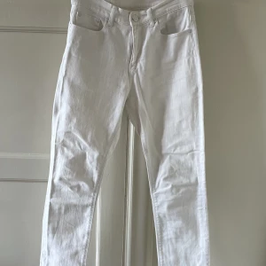 Vita jeans - Vita jeans som är avklippta nedtill med slitningar, har en ”randig” struktur