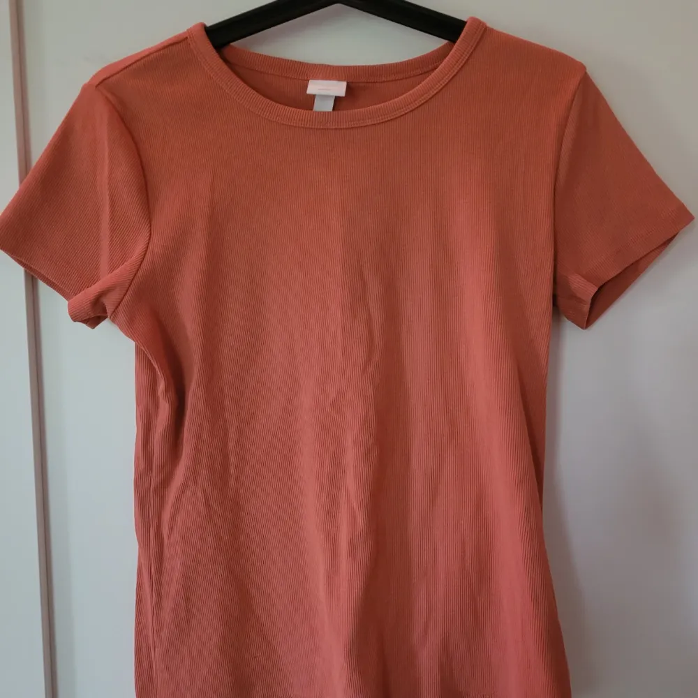 Ribbad T-shirts i orange från H&M. Är i bra skick, används fåtal gånger. . T-shirts.