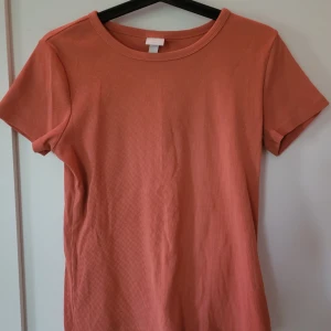 H&m T-shirt - Ribbad T-shirts i orange från H&M. Är i bra skick, används fåtal gånger. 