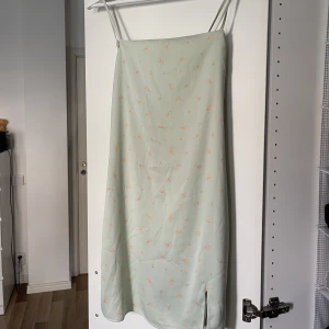 grön satinklänning - säljer nu min fina gröna satinklänning då den inte riktigt sitter som jag vill på min kropp. den är superskön och bara använd 2 gånger. den har en dragkedja i bak och en liten slut på ena sidan. 