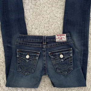 True Religion Jeans - Säljer dessa skitsnygga jeans från True Religion då de tyvärr inte längre passar mig. 🫶 Kan därför inte skaffa bilder där jag bär dem, men innerbenslängden är 75 och midjemåttet 33,5. Lågmidjade med straight/smått bootcut ben. Köpare står för frakt! ❤️