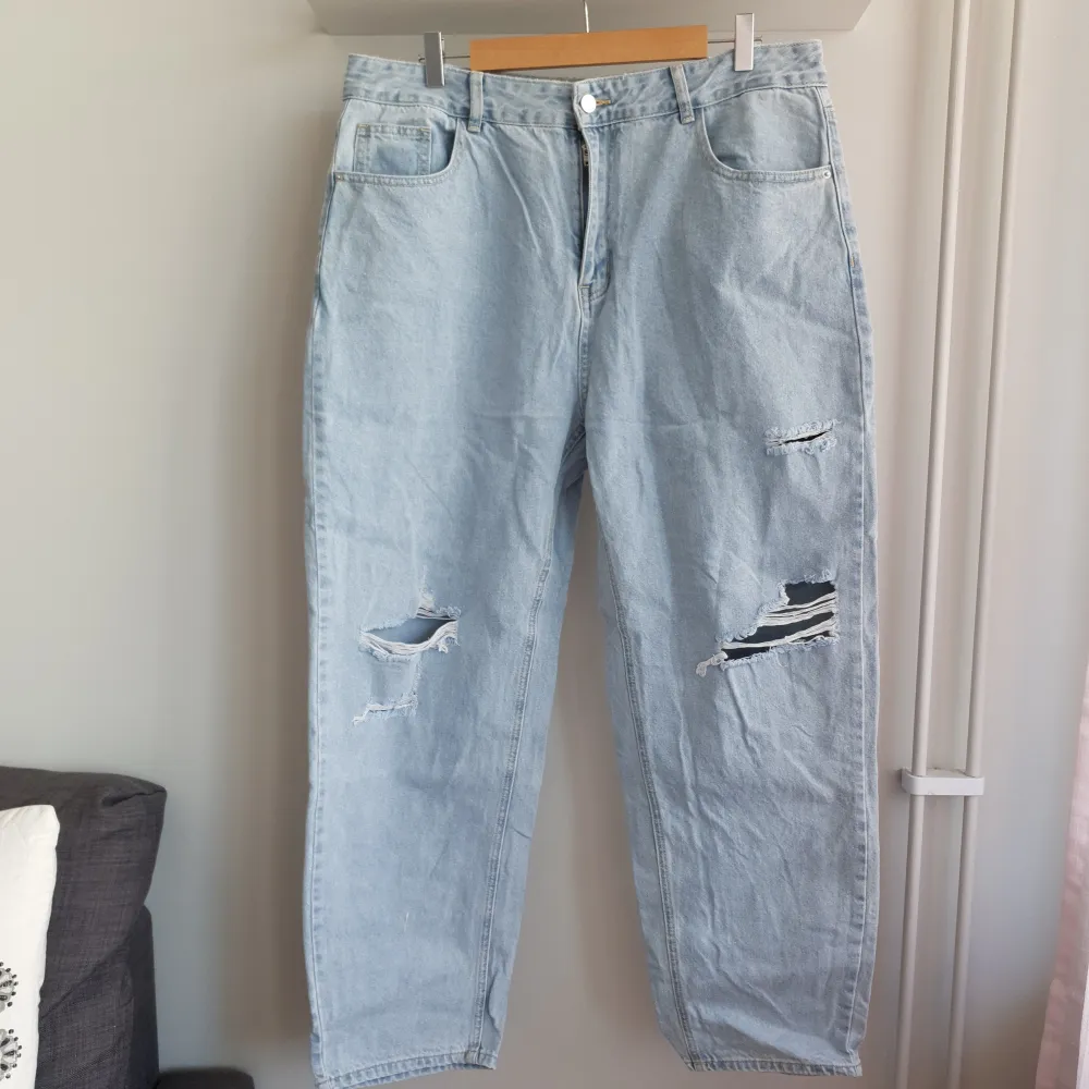 Jeans i vidare modell med slitningar framtill med hög midja. Skulle säga att de är mer som en XL än en XXL. Har aldrig blivit använda utan är enbart provade.. Jeans & Byxor.