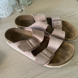 Birkenstock  - Tofflor ifrån birkenstock i en väldigt fin rosa färg! Storlek 37, använt skick men fortfarande i god kvalité. Nypris ligger på ca 1300 kr