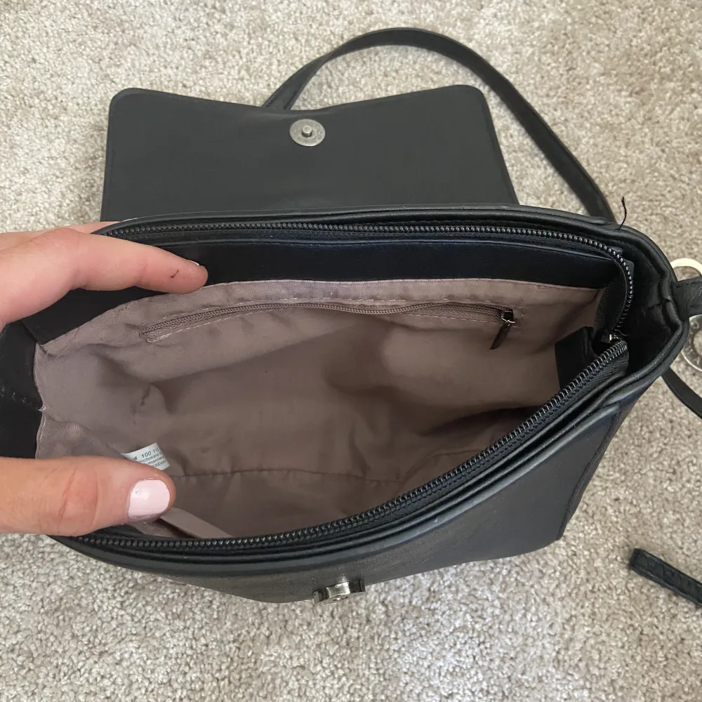 en fin svart handväska, med två fickor inuti! Och ena har dragkedja❤️. Väskor.