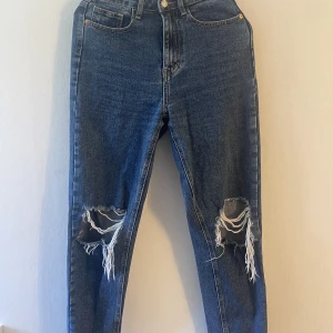 Slitna jeans  - Slitna jeans från prettylittlething. De ser lite roliga ut på bilden eftersom de är upphängda på en galje, annars är de jättefina!  De är i storleken XS/S eftersom det är UK storlekar.  
