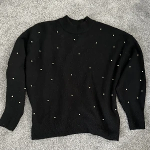 Stickad jumper från H&M - Svart fin stickad jumper i svart med nitade stenar stl XS. Köpt på ARKIVET. 