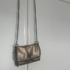 Axelremsväska,guldfärgad - Så snygg väska från ginatricot