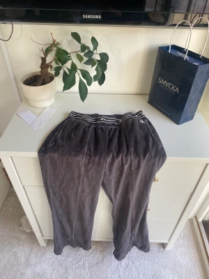 Champion mjukis byxor - Ett par gråa/svarta champion mjukis byxor. Byxorna är vida nere vid fötterna och sitter tajtare vid rumpan och låren. Tyvärr saknas snöret i midjan annars är dem i bra skick 