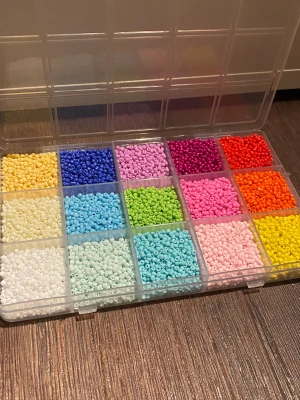 Pärlor - Små pärlor i olika färger, någon färg är använd någon gång men finns väldigt mycket kvar som man kan se! Lådan är ca 16 x 10 cm så inte jätte stor men då pärlorna är små så räcker de länge! 