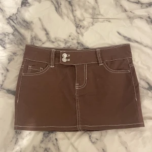 Lågmidjad mini denim kjol - En brun lågmidjad minikjol i denim. Perfekt för höst outfits! Pris kan prutas!! (skriv privat för fler bilder)