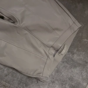 Ljusbeiga byxor - Ljusbeiga fodrade byxor i läderimitation . Aldrig använda