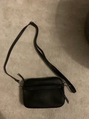 Liten väska - Säljar denna svarta axelremsväska från don donna. Använd fåtal gånger men i bra skick. Nypris 500. Priset kan diskuteras 💕