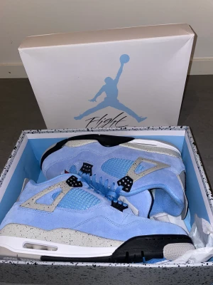Skor - Air Jordan 4 Retro University blue/black  Jag har aldrig använt dom för dom var för stora på mig.  Kommer med box och crease skydd 