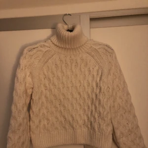Mysig stickad Polotröja - Trendig vit polotröja i kortare modell. Stl xs men sitter som en S. Mycket fint skick endast använd ett fåtal gånger. 