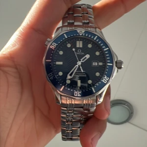Omega Seamaster  - En fin Omega Seamaster i fint skick. Den kommer med två länkar varav en är i gummi (eftermarknad) och box. Klockansglas är gjort av safir och länken är rostfritt stål. Allmänt trevlig klocka som är väldigt stilren. OBS!!! förra ägarens bilder.