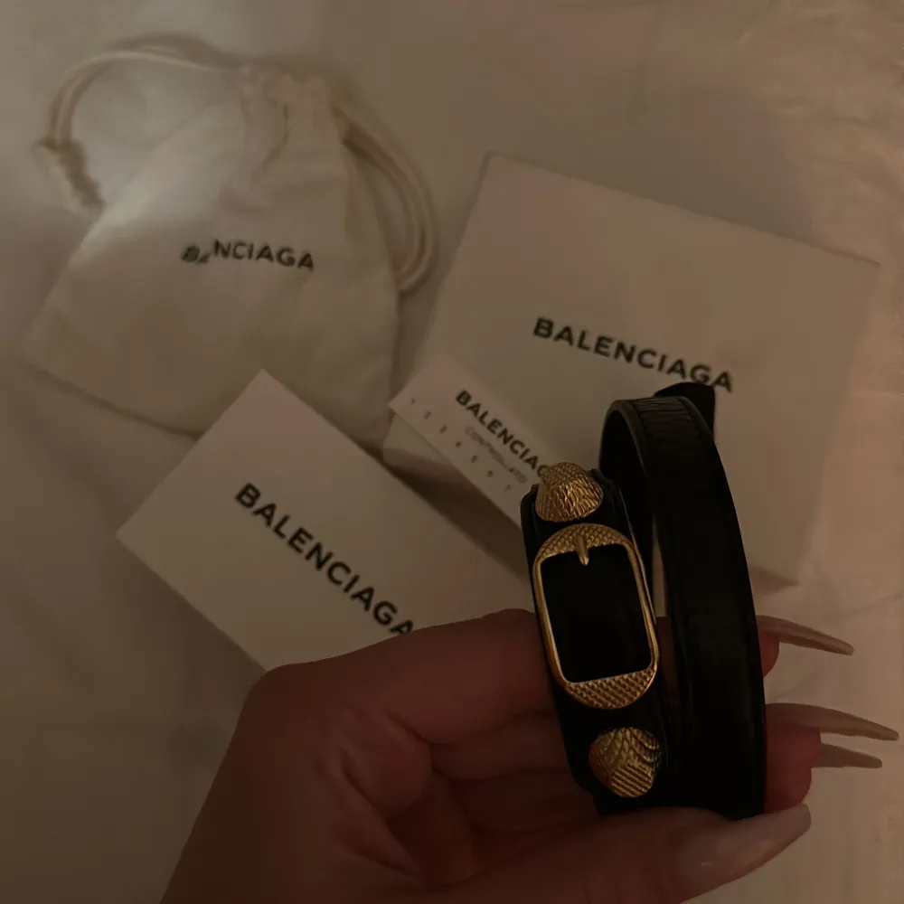 Svart Balenciaga armband med gulddetaljer i storlek M dustbag box och äkthetsbevis tillkommer🧚🏼‍♀️Säljer då de inte kommer till användning💓Armbandet har inga slitningar eller defekter. Accessoarer.