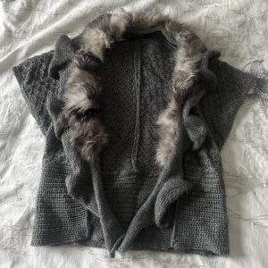 päls väst - stickad - Grå stickad päls väst, inte säker på om det är äkta päls eller inte då den är begagnad. Strl S men funkar upp till M. Köparen står för frakt! Kontakta om du är intresserad eller har övriga frågor, besvarar gärna på dem! Har fler bilder så bara att fråga! :)