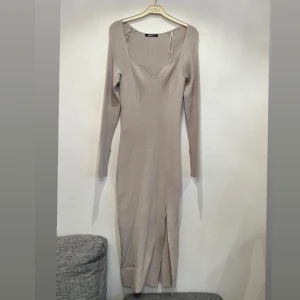 Klänning  -  Fiona knitted dress. Stickad klänning med slits i sidan. Den har en midilängd, hjärtformad ringning, figurnära passform och långa ärmar med slits vid ärmsluten. Passar även M