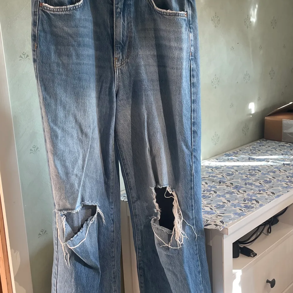 Vida jeans med hål över knäna. De är vida och highwaist passar inte längre. Det är något kortare mot de i butik då jag klippte av de för de var för långa  storlek 40 från ginatricot . Jeans & Byxor.