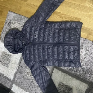 EA7 fodrad jacka - Säljer en Armani jacka som köptes för tre år sen, har inte använts mycket. Skick 9/10, eftersom den har ett litet hål. 