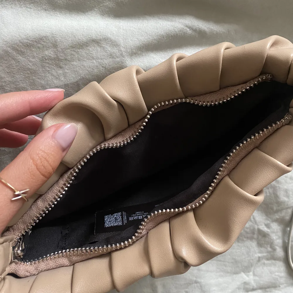 Sjukt snygg beige veckad handväska från Asos som endast är använd 1 gång, som helt ny. Ca 25cm lång & 9cm bred. Perfekt till dag & fest<3. Väskor.