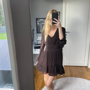 Mönstrad klänning - En mönstrad klänning som är blandning mellan brun och vinröd med svart mönster