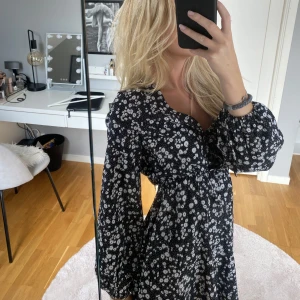 Svart klänning med vit blommor - En fin svart klänning med vita små blommor! Passar både xs och s!