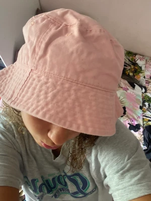 Rosa buckethat - Toppen skick!! Säljer då den inte kommer till användning. Pris:55kr kan samffrakta med andra saker!!