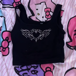 Svart topp med silvriga stenar på sig - Säljer för att den inte kommer till användning, fint skick och har inga fläckar på sig (det som är på bilden är katt hår men det tvättar jag bort innan jag skickar! Klicka på köp om du vill köpa, kontakta om du har frågor!