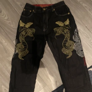 Jeans med sydda ormar  - Svarta jeans 