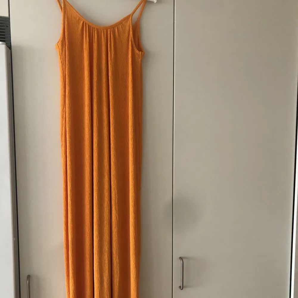 En orange maxiklänning från Ginatricot i storlek S. Tyget är smått plisserat. Klänningen är aldrig använd och i mycket fint skick! . Klänningar.