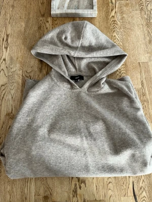 Beige hoodie - Mysig mjuk beige hoodie. Klassisk modell med stor huva och magficka. Ribbstickad kant nedtill och vid ärmsluten. Perfekt för chill dagar eller när du vill ha en enkel och stilren look. Skulle säga att den känns något större än M