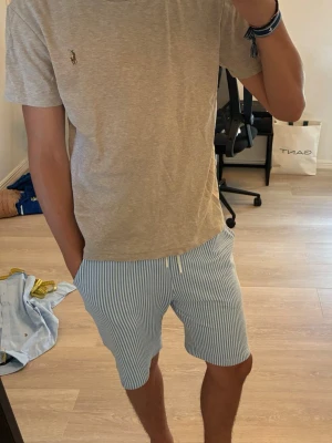 Beige t-shirt från Polo Ralph Lauren - Säljer en stilren beige t-shirt från Polo Ralph Lauren med den klassiska broderade loggan på bröstet. T-shirten har korta ärmar, rund hals och är gjord i mjuk bomull för en skön känsla. Perfekt till jeans eller shorts.