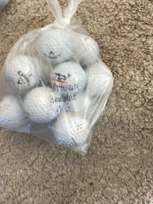 Påse med vita golfbollar - En plastpåse fylld med vita golfbollar, flera av märket Callaway. Bollarna har klassisk dimple-yta och är perfekta för dig som vill fylla på golfutrustningen. Säljes i ett smidigt paket.